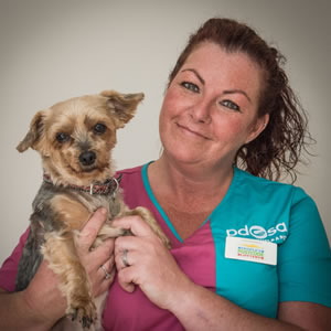 Tina, PDSA Community and Education Vet Nurse, holding a little terrier dog.